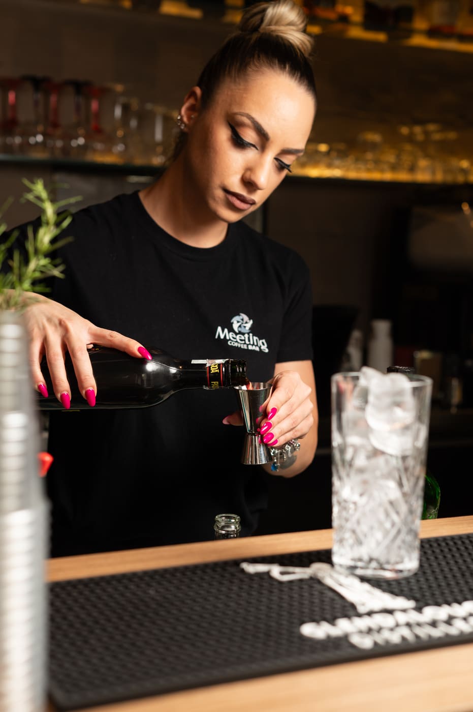 Barista del Meeting Coffee Bar che dosa un distillato al bancone